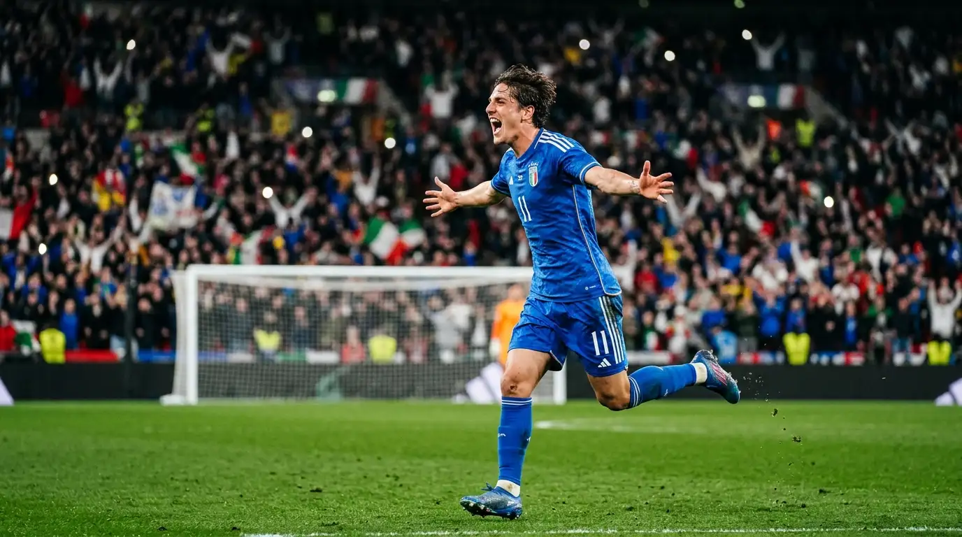 A striker in a blue national-team kit wheeling away in celebration after scoring, arms wide, roaring, blurred floodlit stadium crowd behind