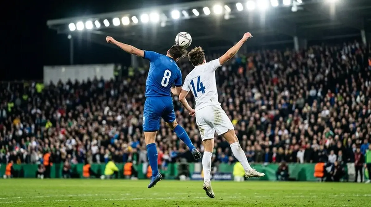 Two soccer players from different national teams contesting a high ball under stadium floodlights during a tense knockout match